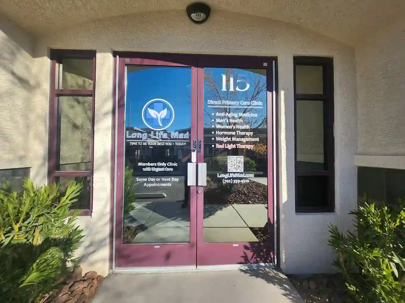 Glass entrance doors to a Las Vegas medical clinic labeled “Long Life Med,” offering personalized healthcare, with clinic services and contact information displayed on the right door.