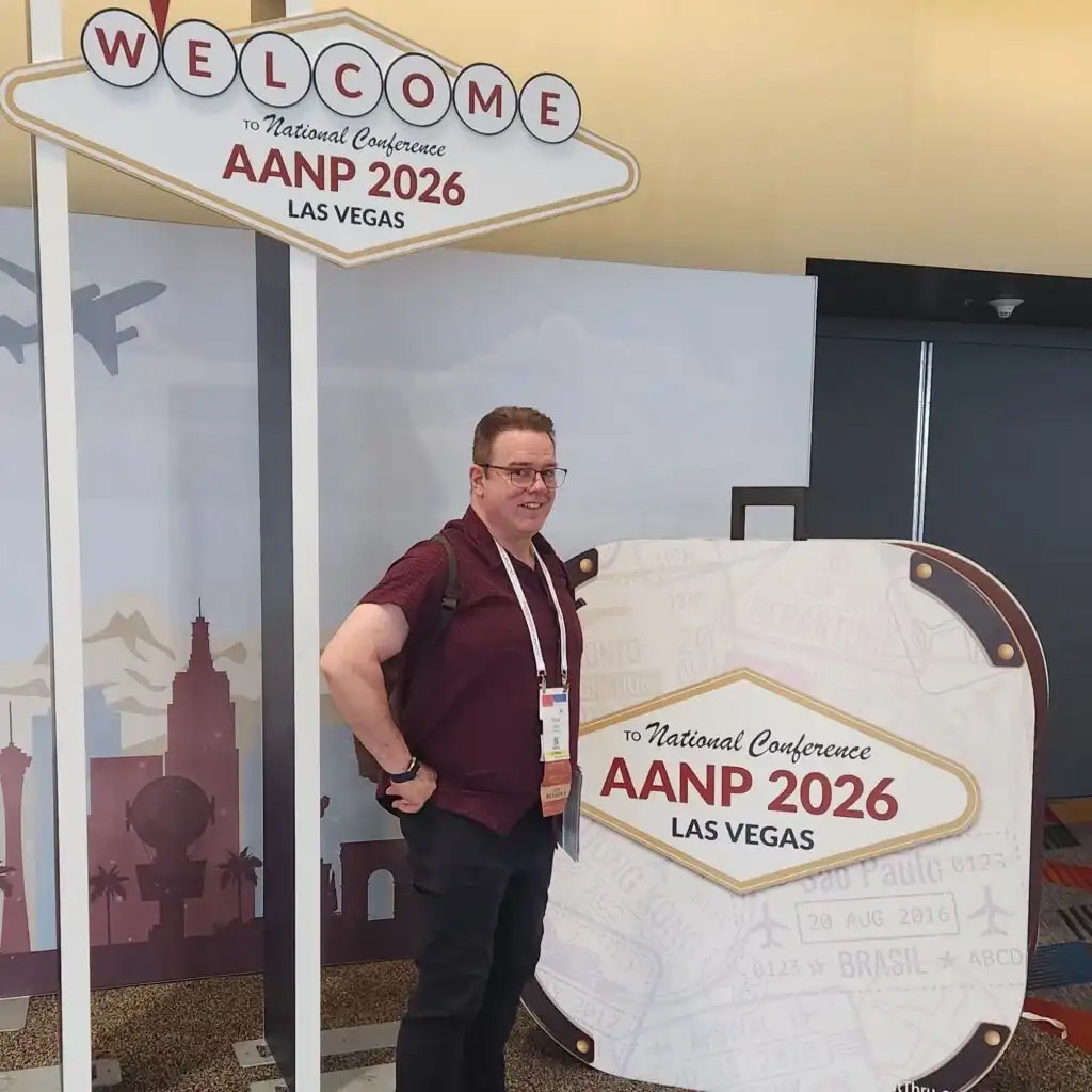 A person stands beside signs welcoming attendees to the AANP 2026 National Conference in Las Vegas, where Brain Health and Continuing Medical Education are at the forefront of the event’s focus.